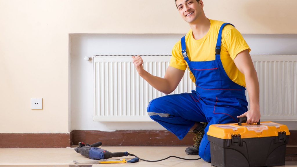 A Kneeling technician was smiling while holding tool box